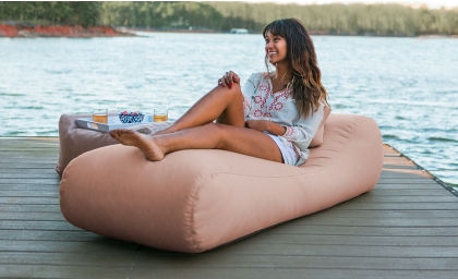 Woman on dock laying on the Arlo Outdoor Bean Bag Lounger