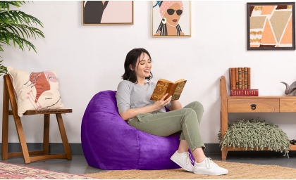 Woman reading while resting on the Saxx 3 bean bag chair