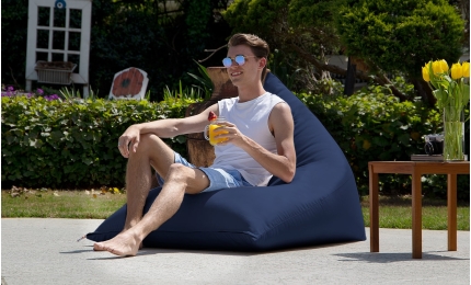 Man drinking juice on the Twist Outdoor Bean Bag Chair 
